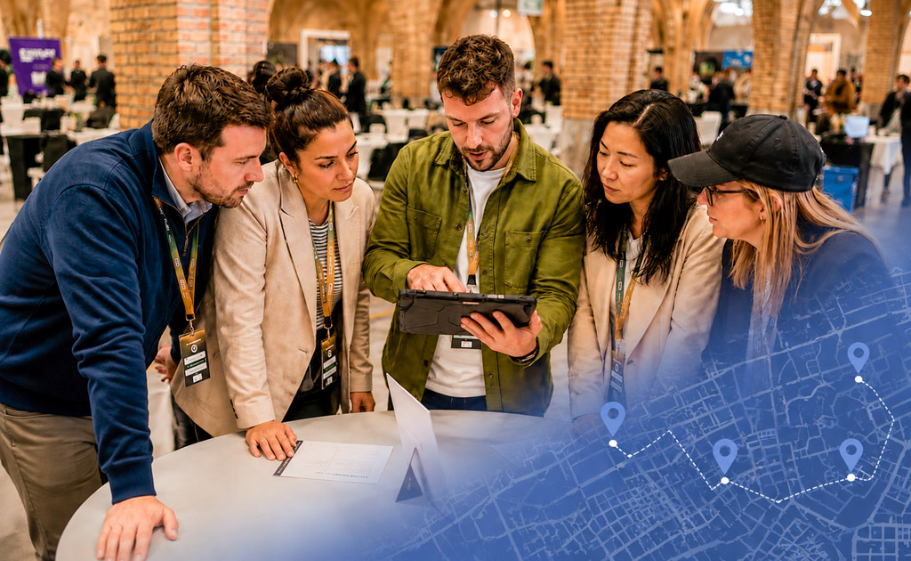 Collega's werken samen aan een interactieve teambuildingopdracht met een tablet tijdens een bedrijfsbijeenkomst.