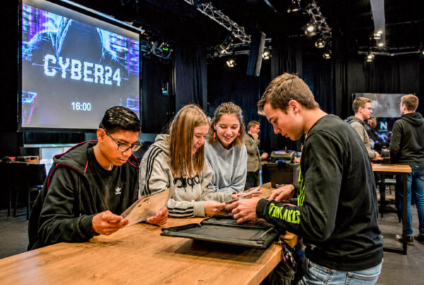 Studenten werken samen aan een interactieve serious game voor onderwijs en samenwerking.