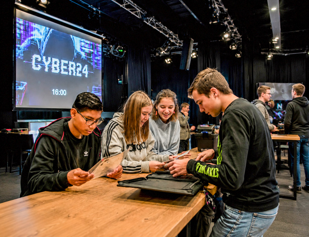 Studenten werken samen aan een interactieve serious game voor onderwijs en samenwerking.