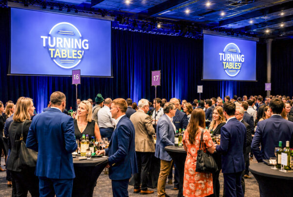 Bezoekers van een zakelijk evenement beleven een interactieve activiteit op een eventlocatie.