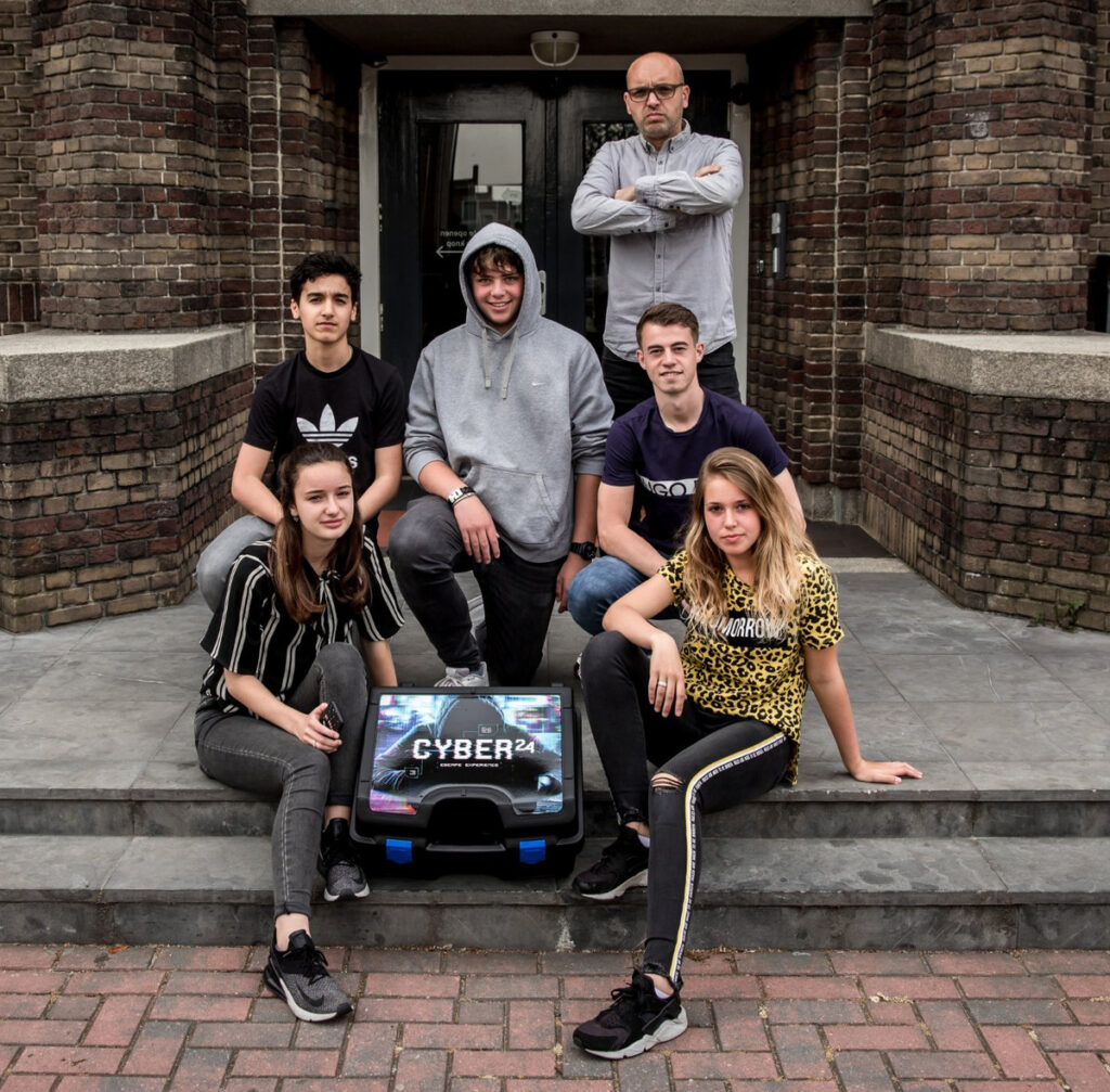 Leerlingen en hun docent op de schooltrap met de Cyber 24 escape-koffer